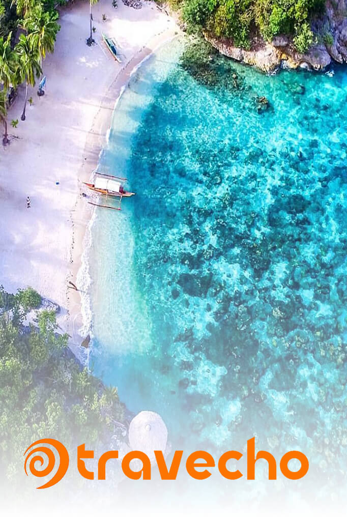 TRAVECHO - Philippines Travel Companion - Aerial view of pristine tropical beach with crystal clear turquoise waters and traditional boats